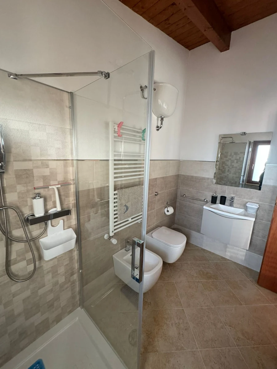 Bagno moderno con doccia e piastrelle chiare
